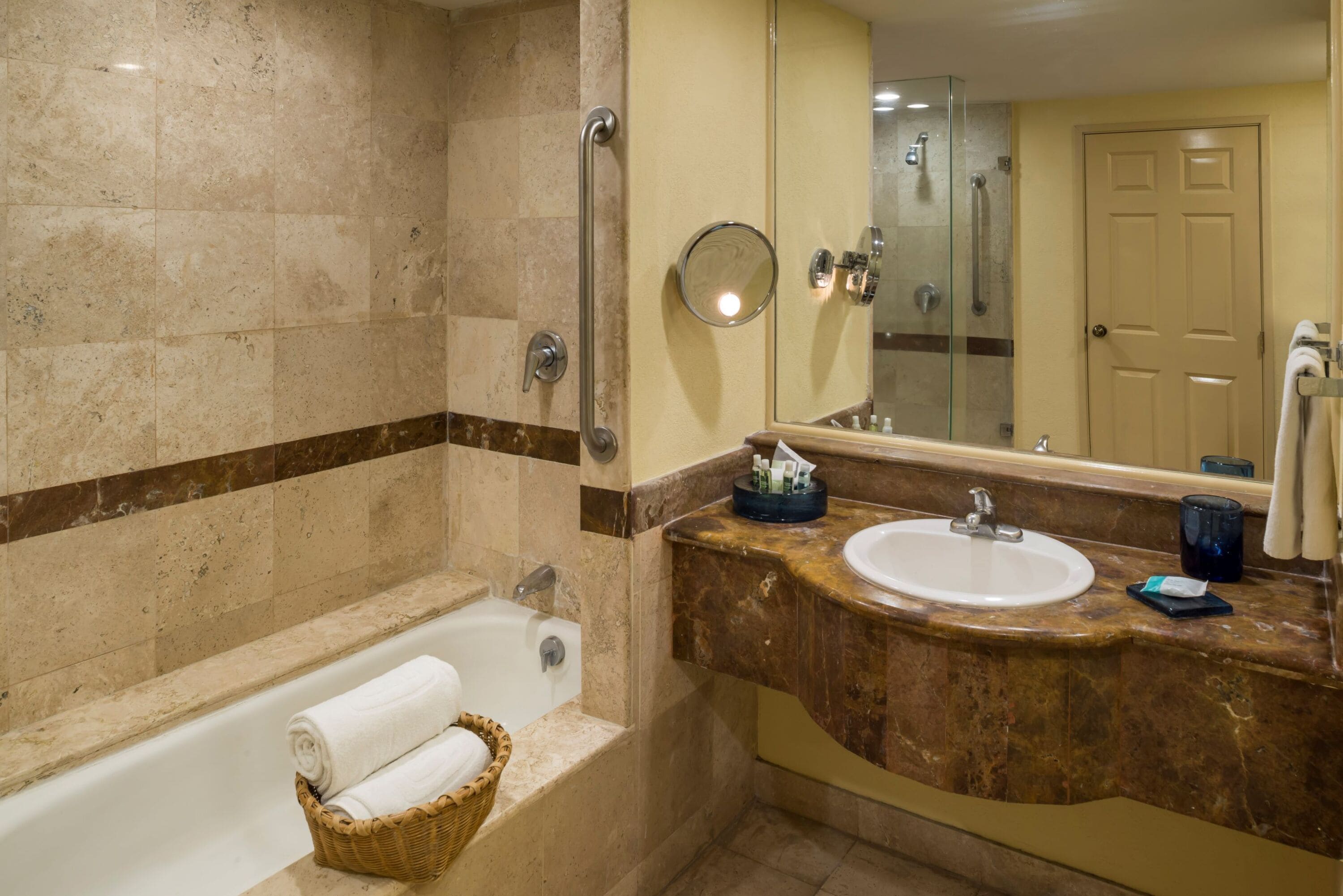Un baño con bañera, lavamanos, espejo y puerta.
