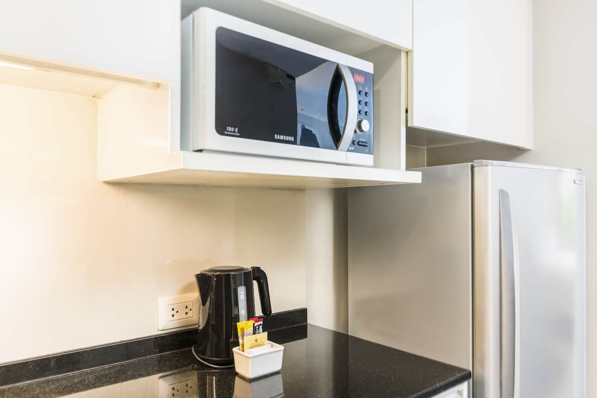 Kitchen features a microwave oven, coffee maker, and refrigerator.
