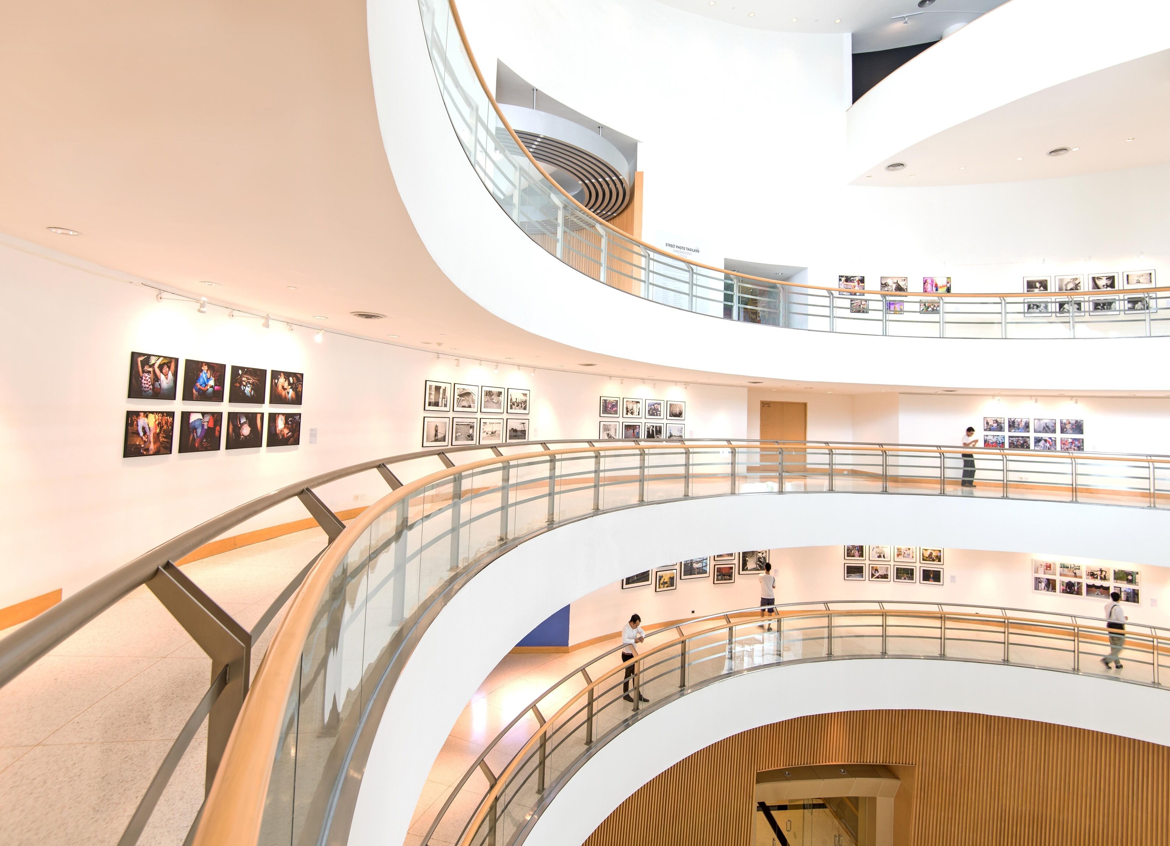 A multi-level atrium with glass railings and artwork on the walls.
