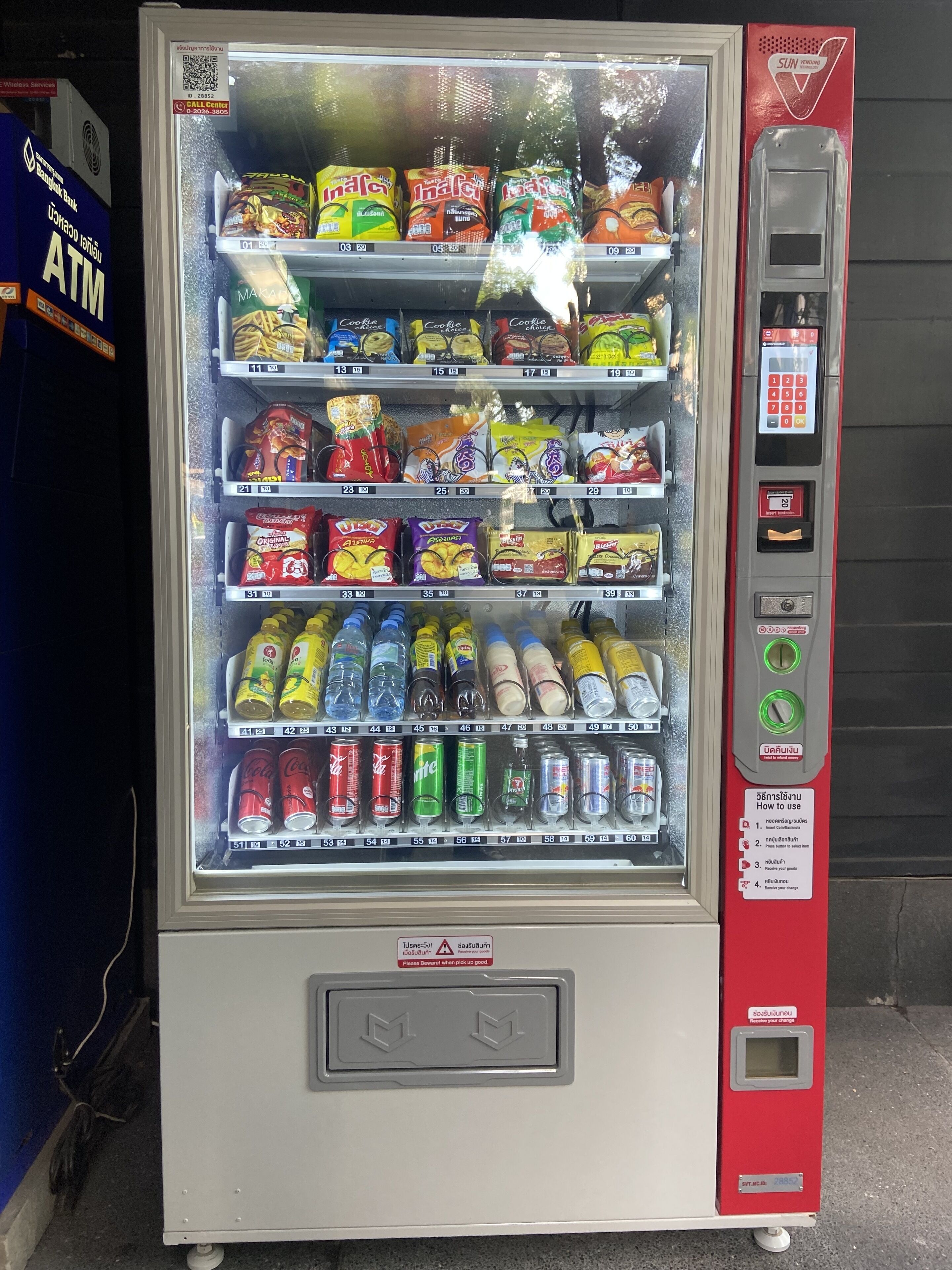 A vending machine with snacks, drinks, and a payment terminal.