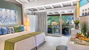 A hotel room with a bed, a desk with a fruit platter, a view of the outdoors, and a painting on the wall. - Forte Village Resort – Hotel Pineta (Pula)