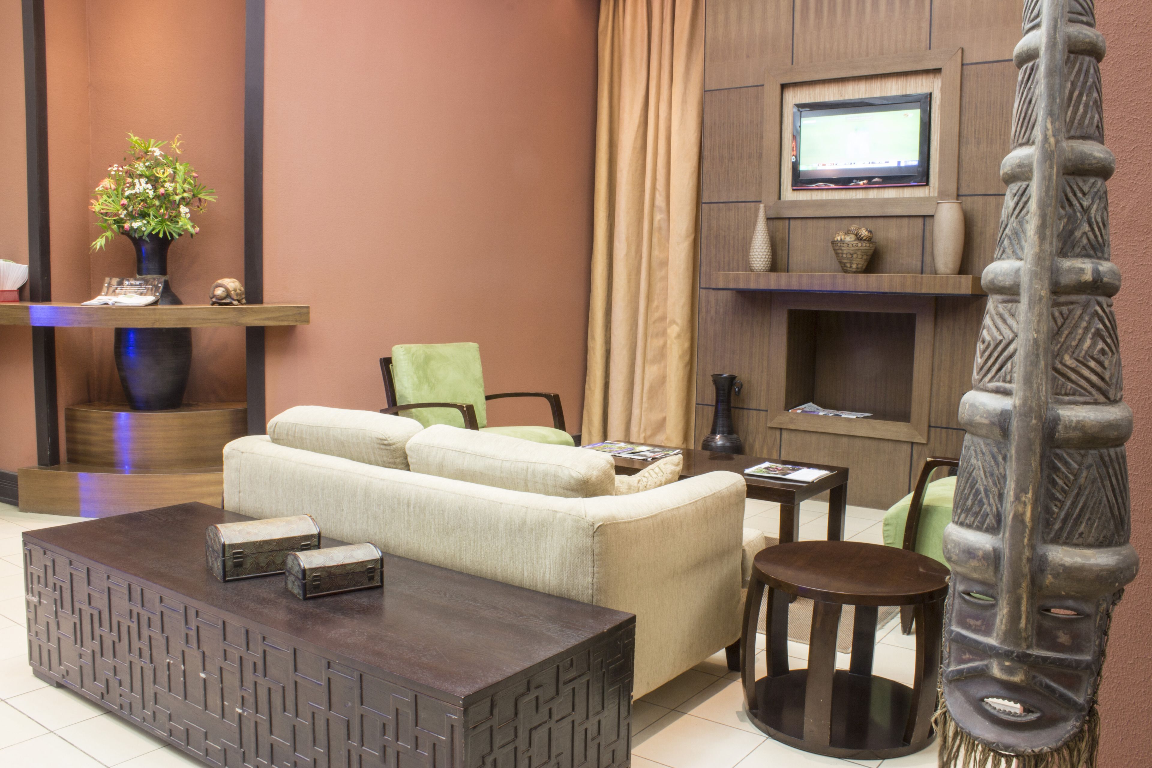 Una sala de estar moderna con sofá, mesa de centro y televisor montado en la pared.
