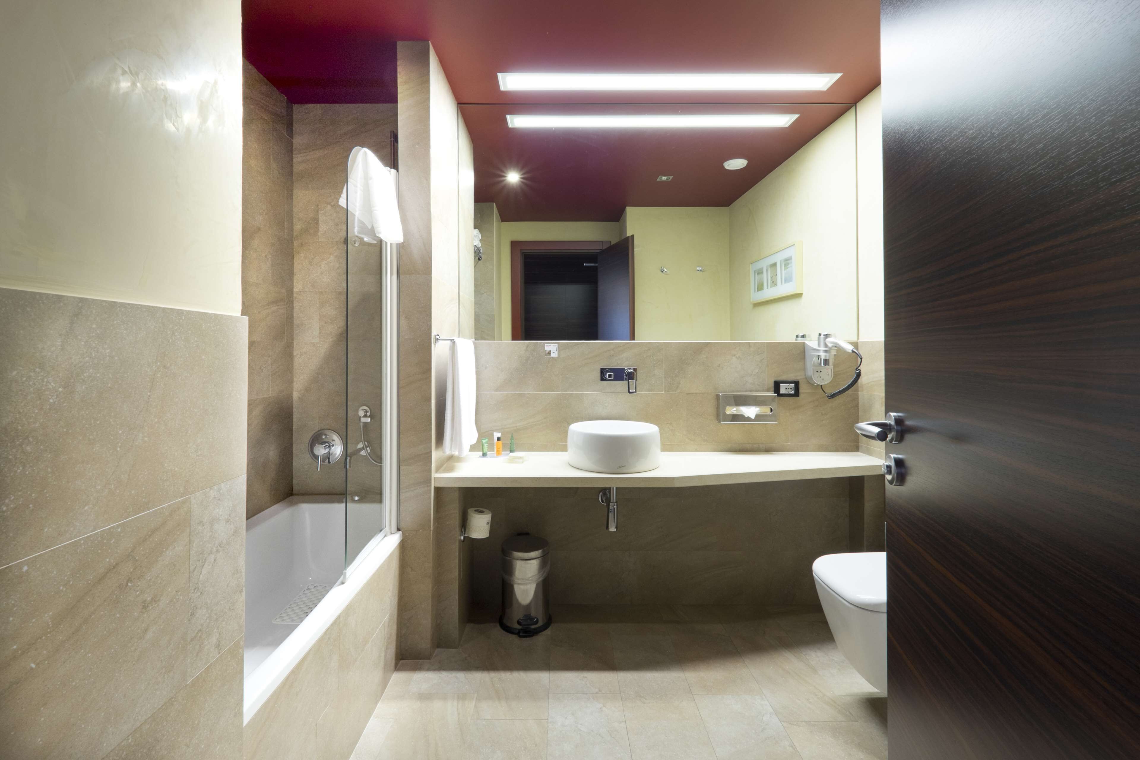 A modern bathroom with a bathtub, toilet, and sink.