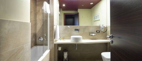 A modern bathroom with a bathtub, toilet, and sink.