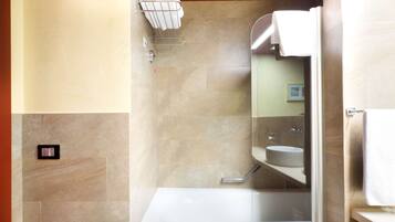 A modern bathroom with a glass-enclosed shower, a white sink, and a towel rack.