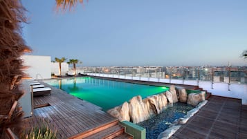 Una piscina al aire libre de temporada, sillones reclinables de piscina