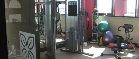 A gym with a variety of equipment including a squat rack, a bench press, and free weights.