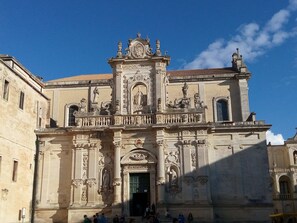 A historic building with ornate architectural details, including statues and columns.