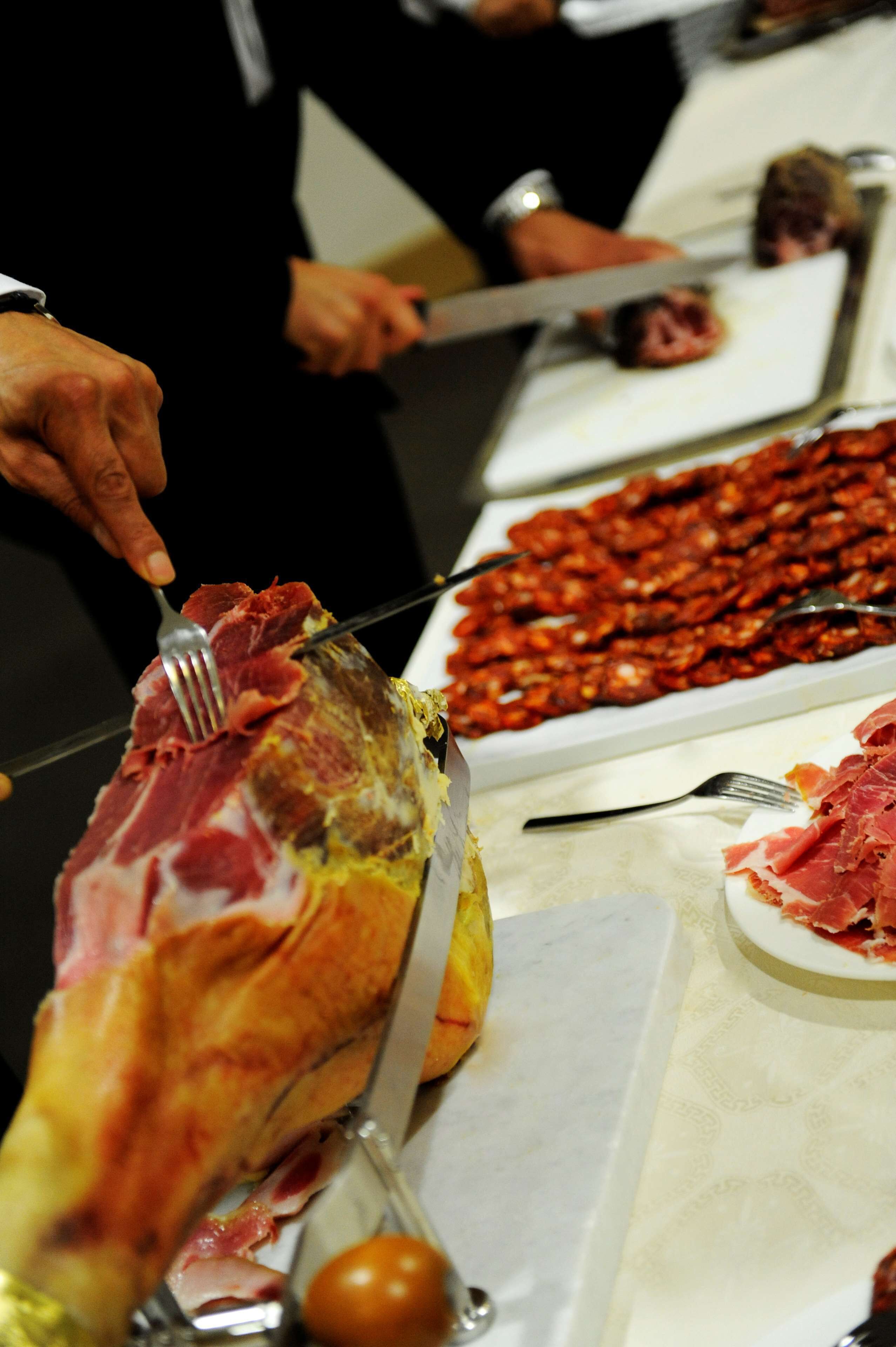 A person carving meat on a table.