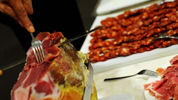 A person carving meat on a table.