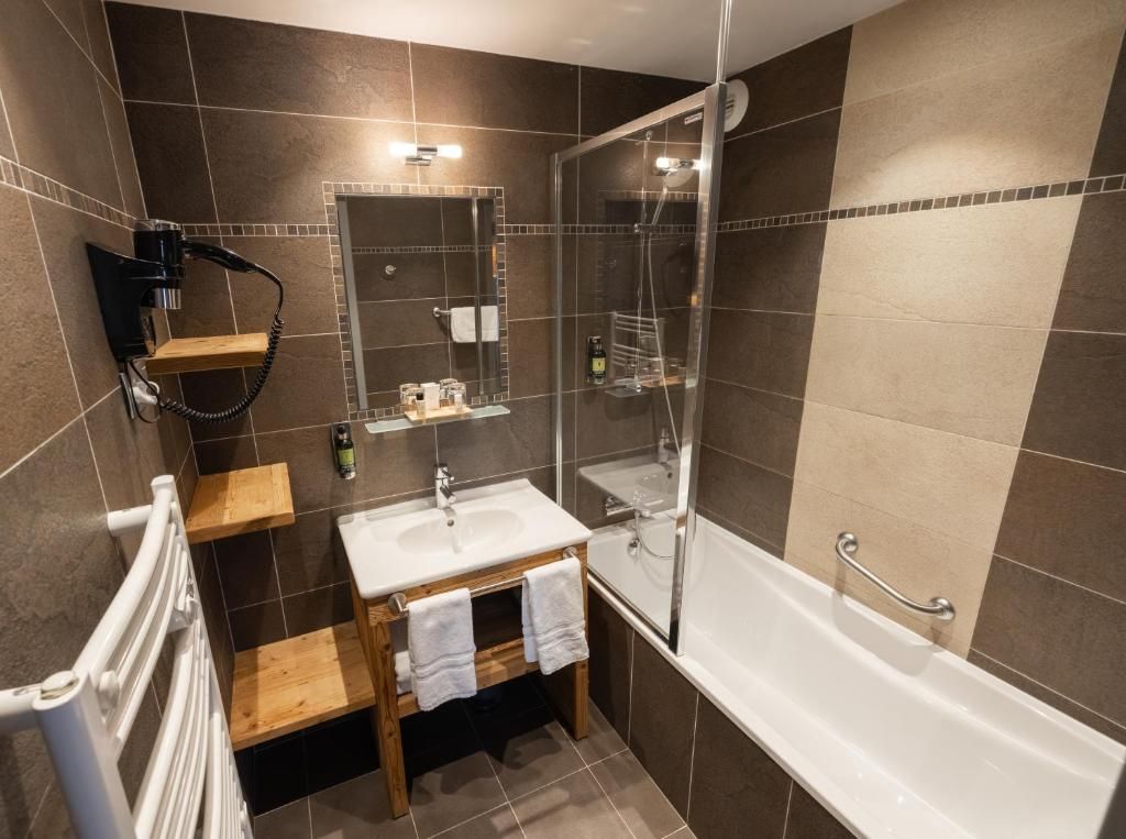 Moderni kylpyhuone, jossa on suihku, pesuallas ja wc.