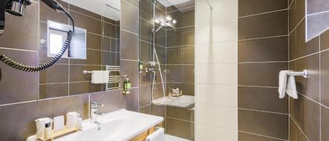 A modern bathroom with a large mirror, a sink, a shower, and a towel rack.