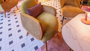 A retro-styled lounge area with a sofa, armchairs, a coffee table, and a dining table.