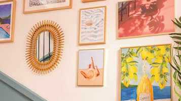 Uma escadaria com corrimão e uma parede decorada com diversas obras de arte emolduradas.