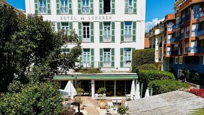 A hotel with a central courtyard, outdoor seating, and a covered area.
