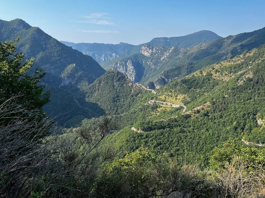 Een bergachtig landschap met dichte bossen en rotsachtig terrein.