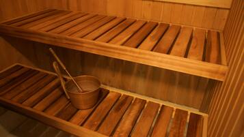 Una sauna de madera con dos bancos y un cubo.