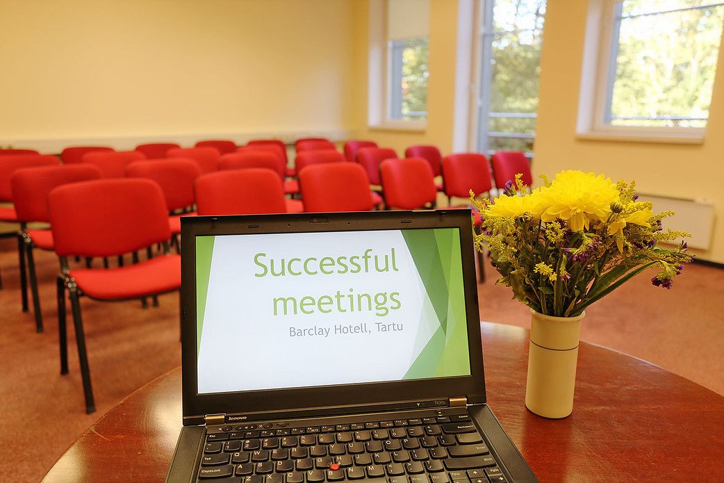 A laptop on a table displaying 'Successful meetings' at Barclay Hotel, Tartu.