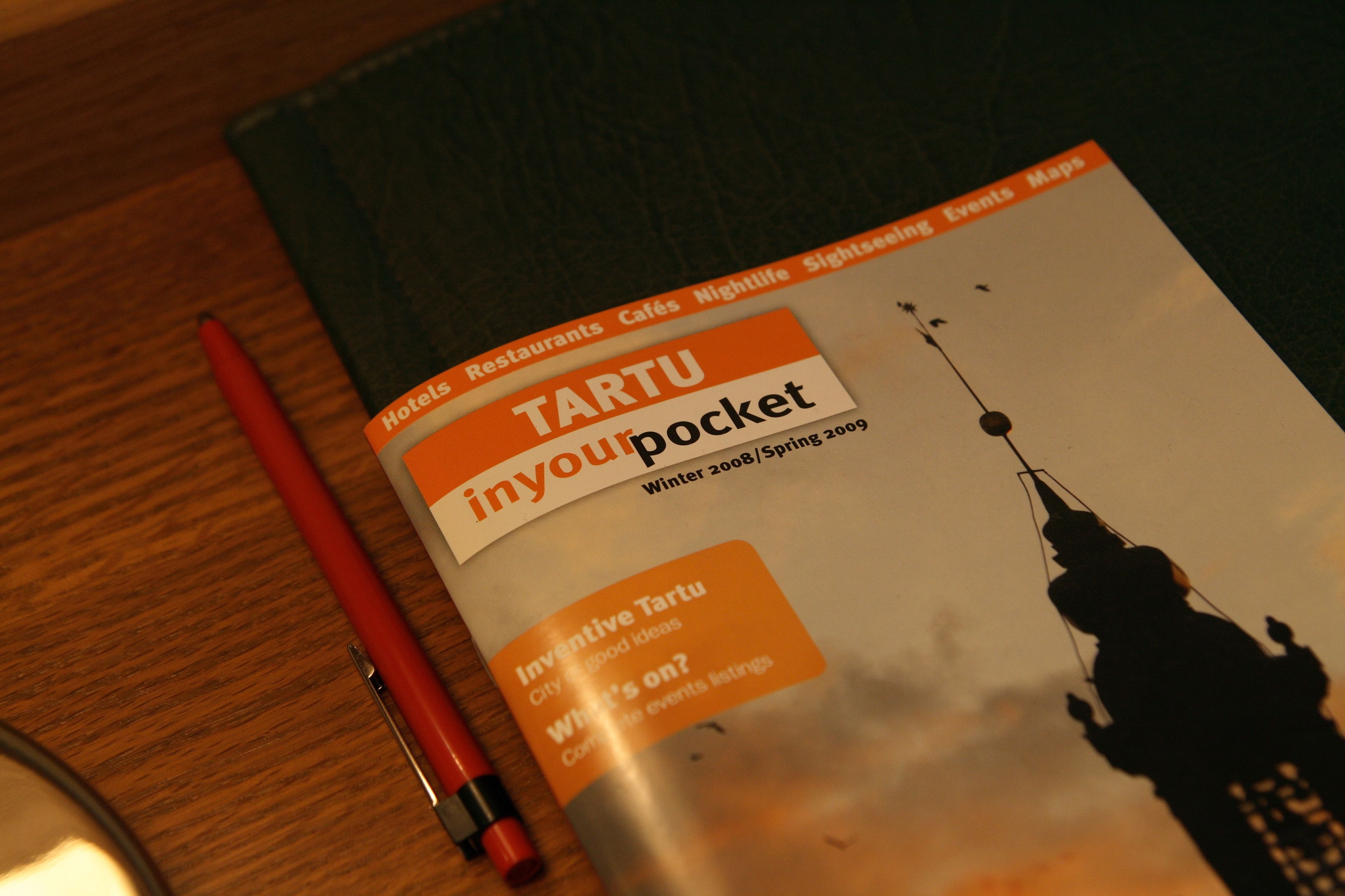Une brochure « Tartu inyourpocket » avec une silhouette de la ville en arrière-plan.