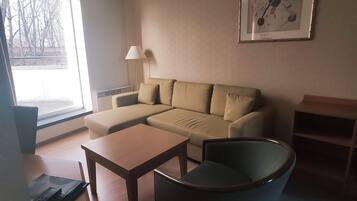 Uma sala de estar moderna com um sofá, uma mesa de centro, uma poltrona e um abajur.