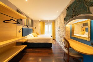 Quarto com cama, mesa de cabeceira, cadeira e espelho.