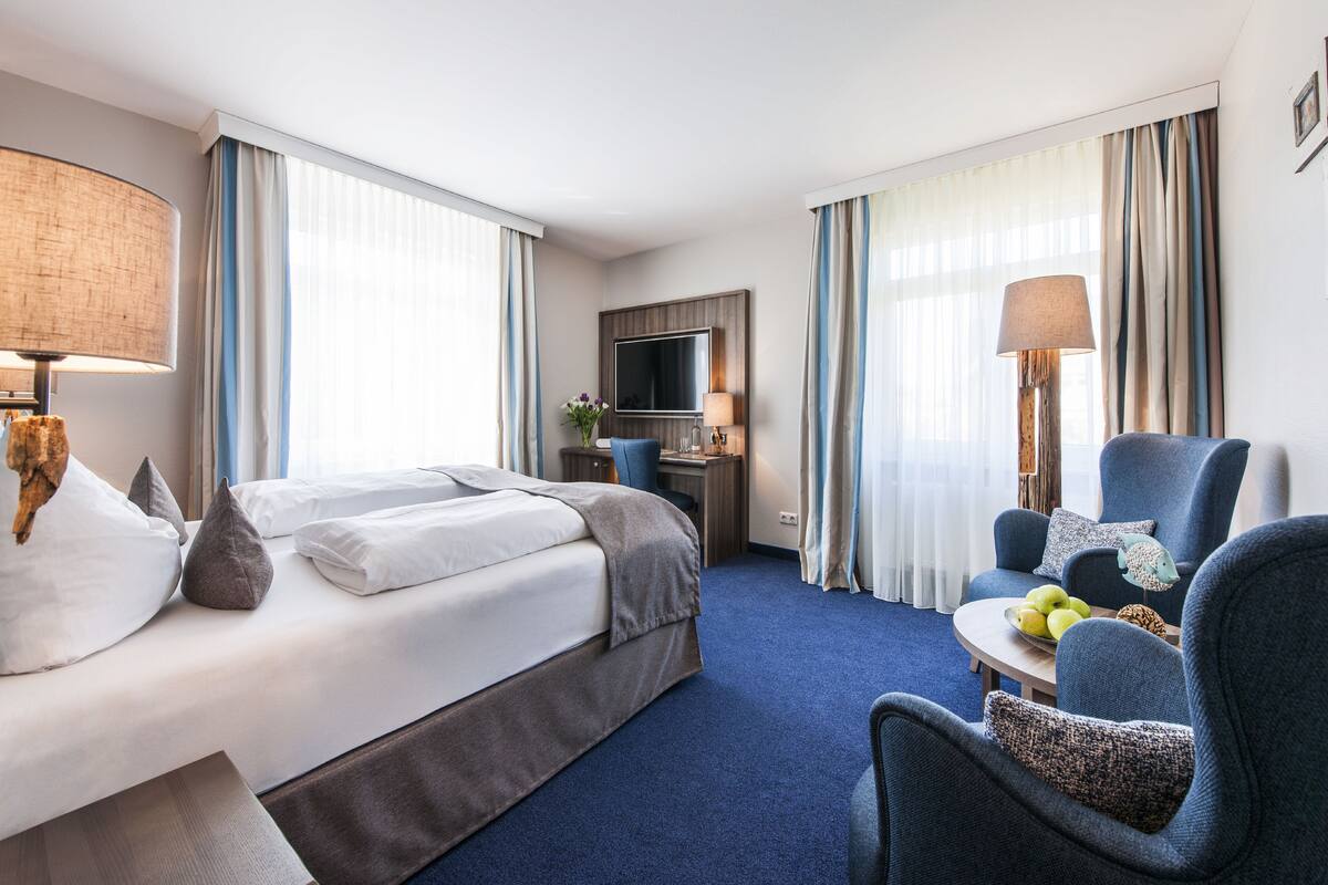 Een hotelkamer met een bed, een bureau, een stoel en een televisie.