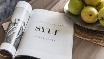 A magazine with the title 'SYLT' on a table next to a bowl of green apples.