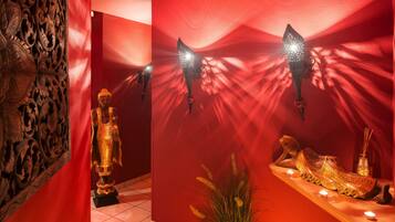 Une pièce avec un mur rouge, une statue et un élément décoratif mural.