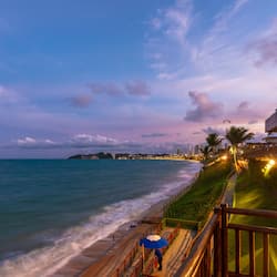 Enjoy a serene beachside promenade with a pathway and seating area overlooking the ocean.