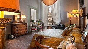 A hotel room with a bed, a desk, a chair, a dresser, and a window with curtains. - Hotel Palazzo Guadagni (Florence)