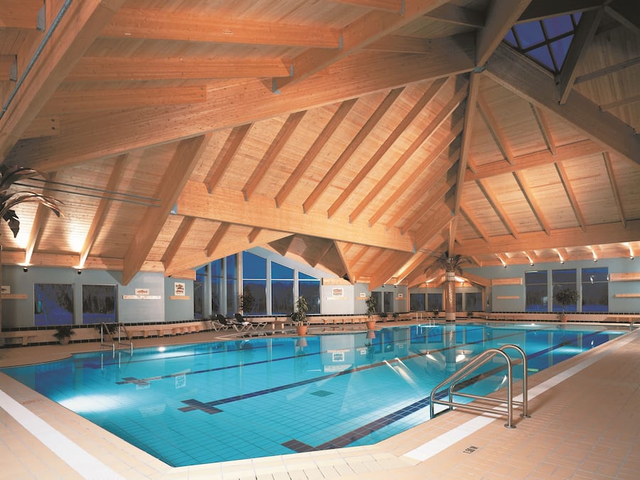 Una piscina techada, sillones reclinables de piscina