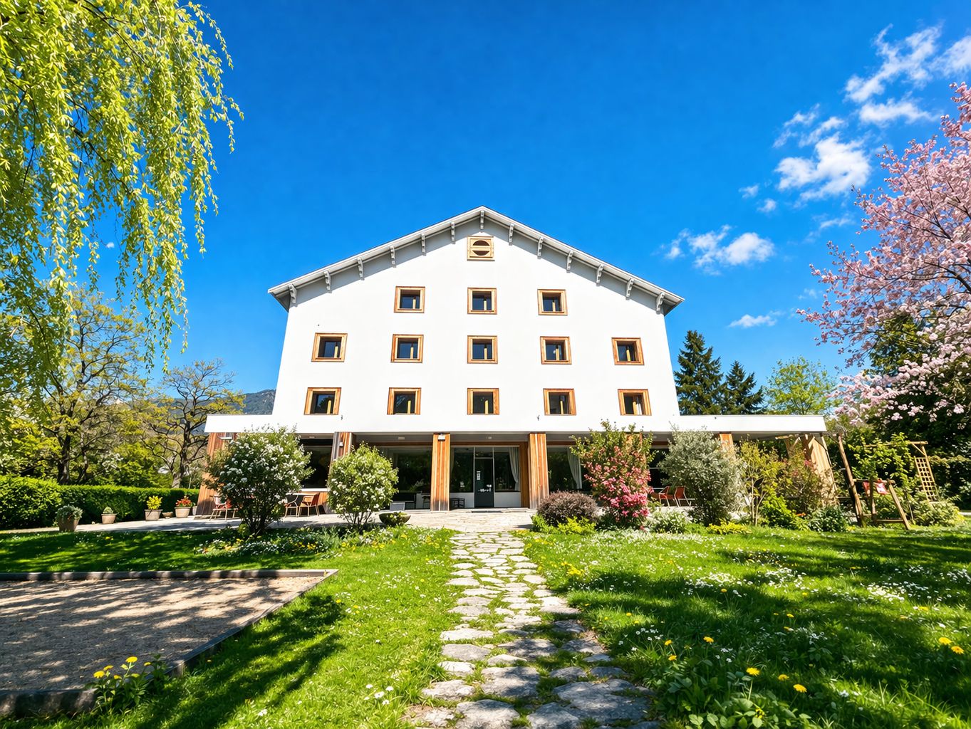 Un immeuble à étages doté d’une façade symétrique, d’une entrée centrale et d’un jardin bien entretenu, avec un chemin de pierre menant à l’entrée.