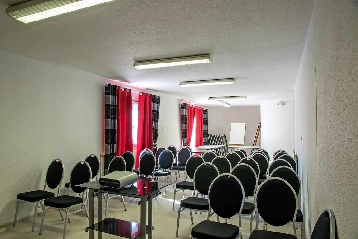 A conference room with rows of chairs, a projector, and a whiteboard.