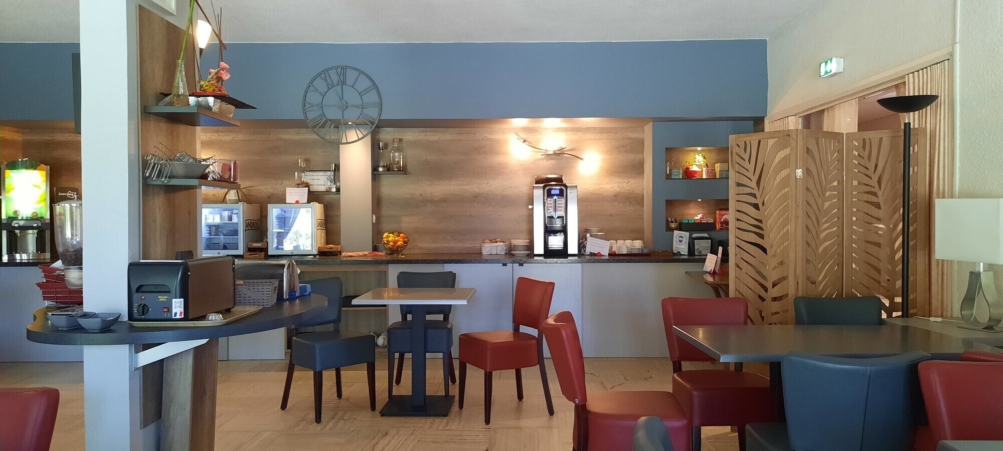 A restaurant with a bar area, seating, and a clock on the wall.