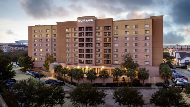 A Courtyard by Marriott hotel with a central courtyard, multiple floors, and a parking lot. - Courtyard By Marriott Houston Medical Center Reliant Park (Houston)