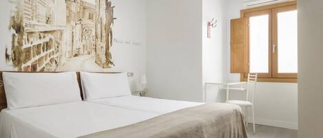 Una habitación de hotel con una cama grande, un escritorio y una ventana.