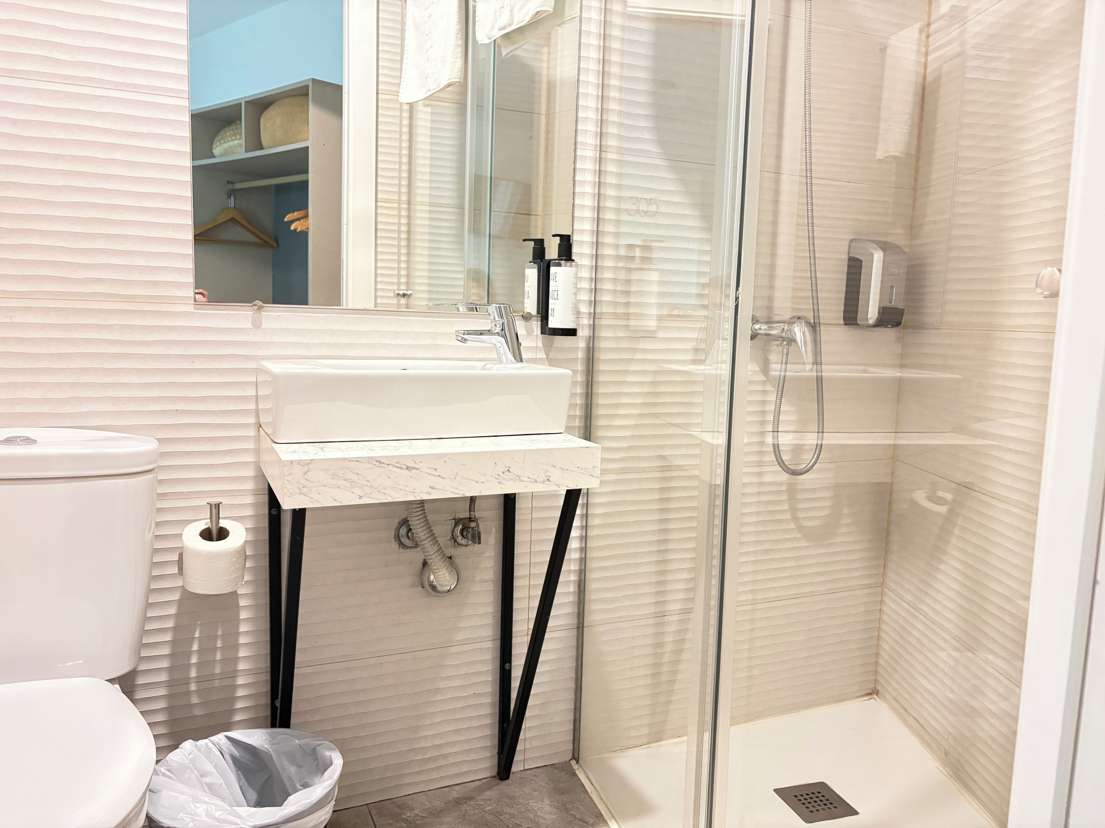 Un baño con inodoro, lavamanos y ducha.