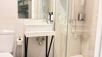 Un baño con inodoro, lavamanos y ducha.