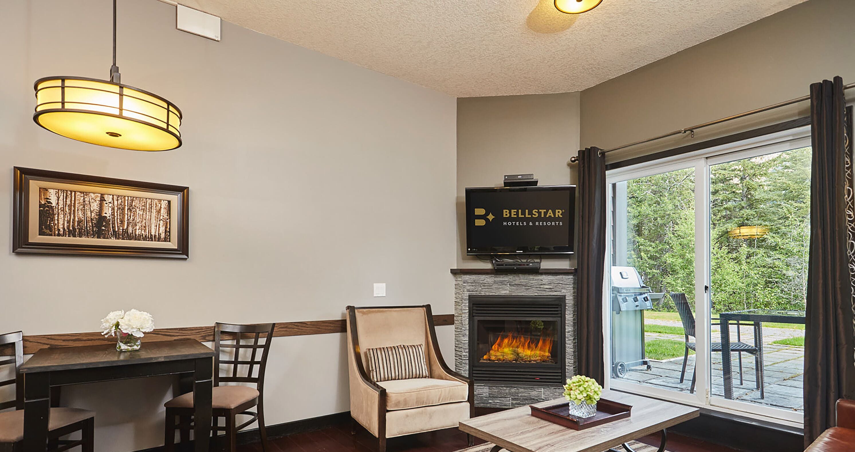 A cozy living area with a fireplace, a television, and a dining table with chairs.