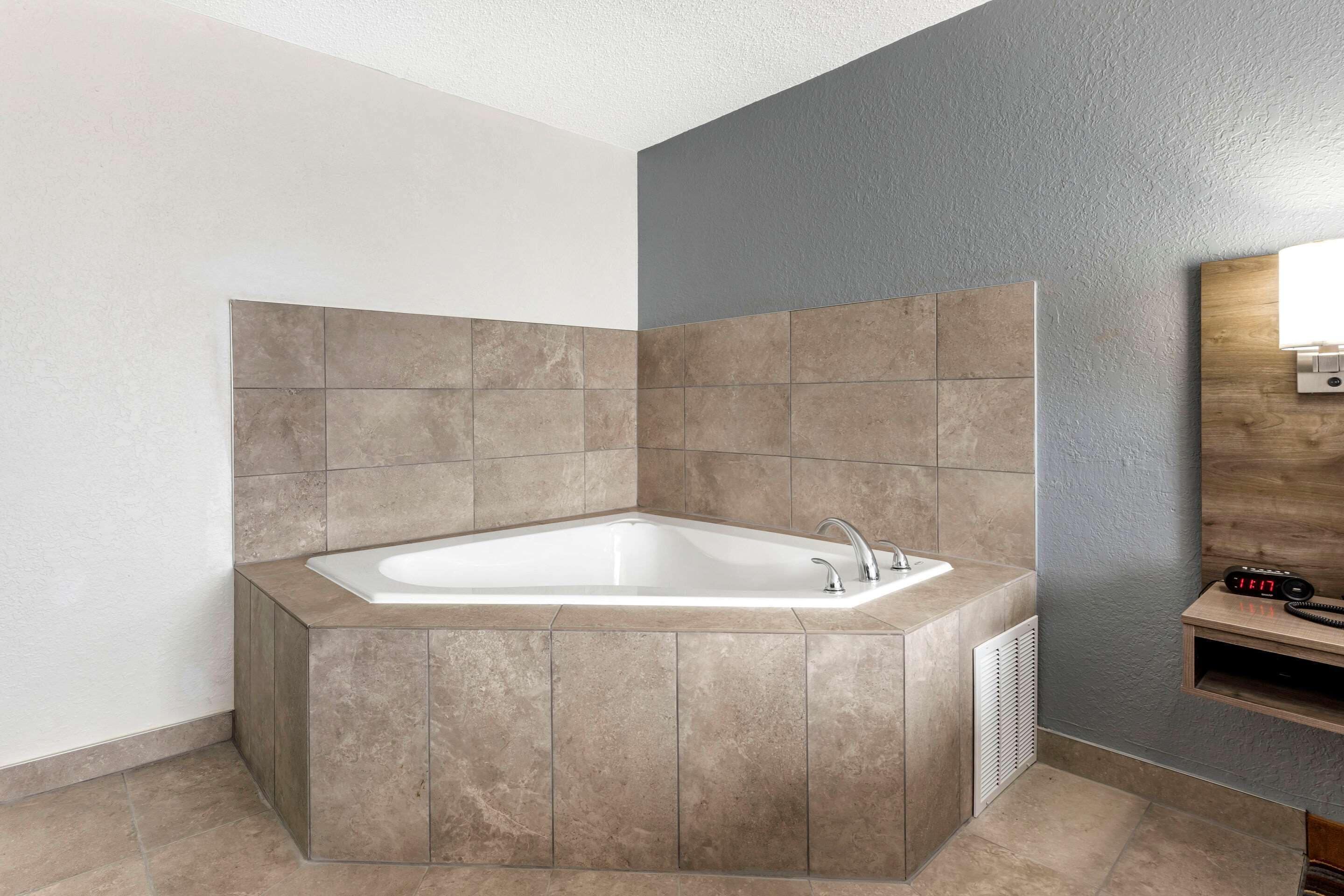 A modern bathroom with a freestanding bathtub, a built-in vanity, and a wall-mounted light fixture.
