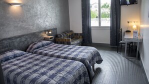 A hotel room with two beds, a small sofa, a desk, and a TV on the wall. - Relais 500 de Vienne (Chonas-l'Amballan)