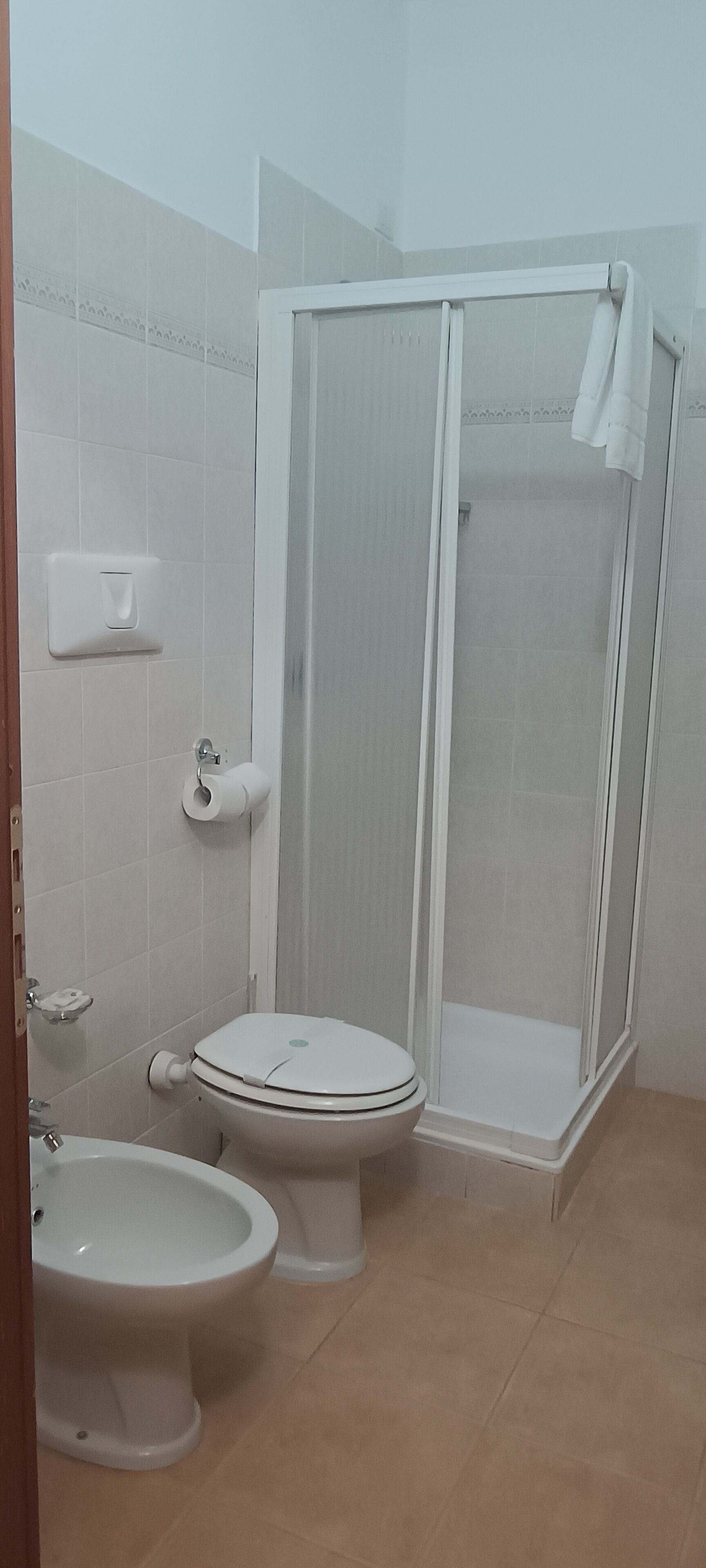 Un baño con inodoro, bidé y cabina de ducha.