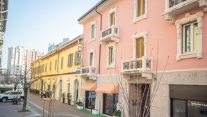 A row of traditional European-style buildings with balconies and storefronts. - Nuovo Rondò (Sesto San Giovanni)