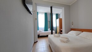 A hotel room with a large bed, a smaller bed, and a bathroom visible through an open door. - Nuovo Rondò (Sesto San Giovanni)