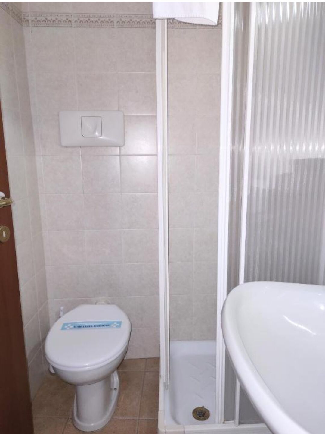 Et badeværelse med toilet, bruser og vask.