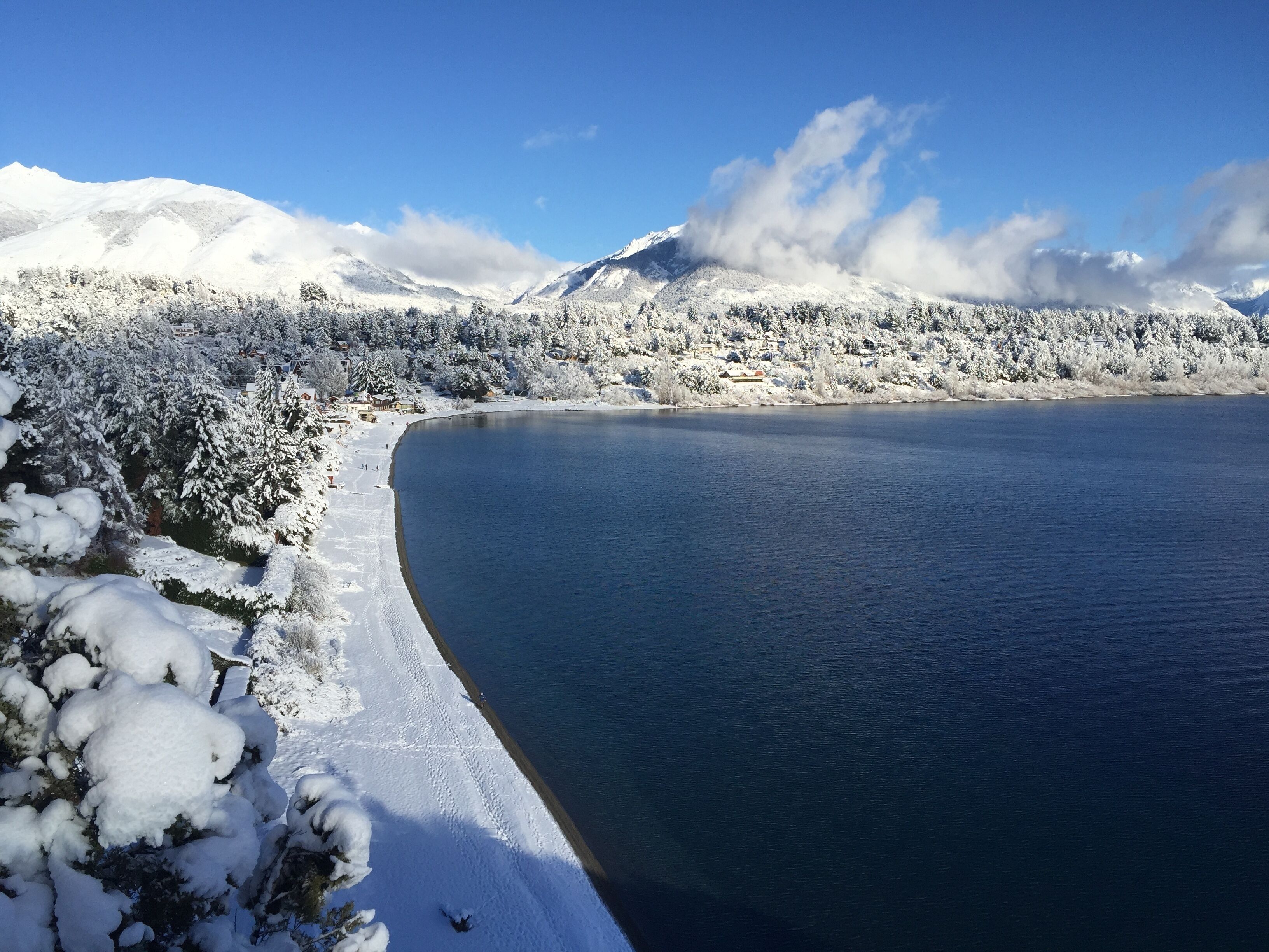 A snow-covered beach with a clear view of mountains in the background.