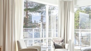 Una sala de estar moderna con un ventanal grande, una mesa de centro blanca y un sofá.