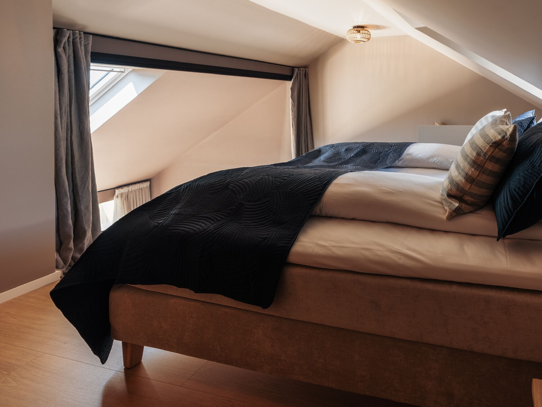 A bedroom with a bed, a window, and a ceiling light.