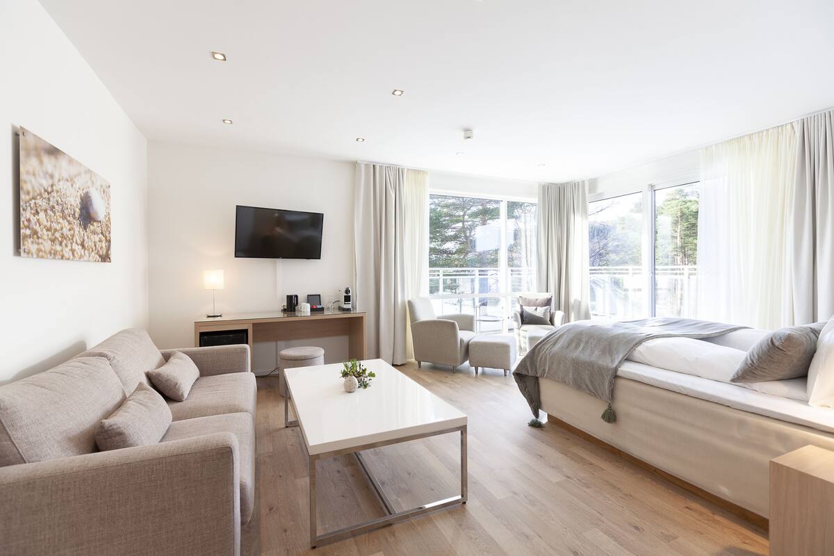 Ein modernes Wohnzimmer mit einer Couch, einem Couchtisch, einem Fernseher und einem Schreibtisch.