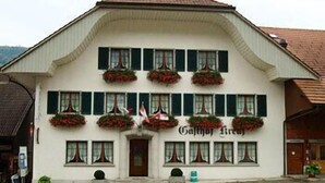 Ein weißes Gebäude mit einem steilen Satteldach und zahlreichen Fenstern.